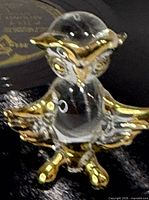 Front view of clear glass owl figurine showing gold-tone wings, head and feet