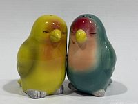 Front view of both ceramic lovebird shakers joined together
