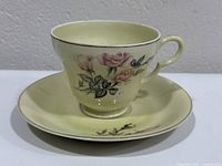 Teacup on saucer showing floral design and cream color