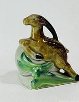 Left side profile of ceramic goat salt shaker on foliage base