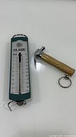 Front view of Globe scale and mini hammer keychain