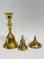 Front view of brass hand bell and two pierced dome covers