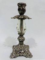 Front view of ornate silver-tone candlestick with crystal stem