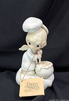 Front view of Precious Moments E-9274 angel chef figurine with hang tag visible