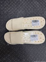 Top view of both beige bathroom sandals in plastic