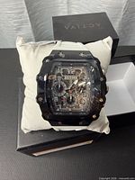 Front view of Activa skeleton watch on cushion in box