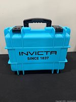 Front view of blue Invicta watch case showing logo and latches