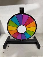 Front view of multicolour dry-erase prize wheel on black stand