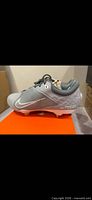 Left side view of grey Nike Hyperdiamond 4 Elite cleat showing Swoosh and React logo