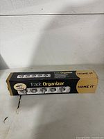 Front view of boxed Home It Track Organizer showing brand and product name