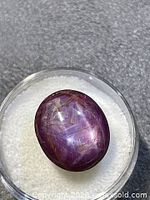 Oval purple star ruby cabochon in dish