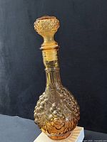 Full view of amber pressed glass decanter with stopper inserted