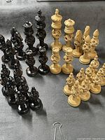 Full set of dark and light puzzleball carved chess pieces on fabric surface
