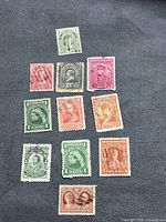 Overall view of the 12 Newfoundland stamps laid out on dark background