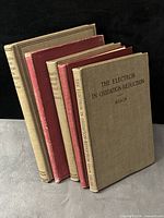 Five chemistry textbooks standing upright showing spines and covers