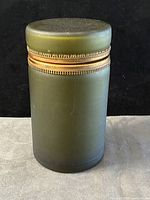 full view of closed satin green glass casket showing bronze mount