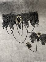 Set showing choker, bracelet cuff, hand chain and ring