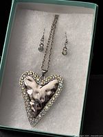 Necklace and earrings in box, heart pendant showing rhinestone border