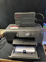 HP OfficeJet Pro 8210 printer with APC Back-UPS ES 350 placed on top, power cables visible