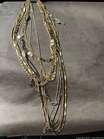 Full view of mixed necklaces piled together showing varied finishes and link styles