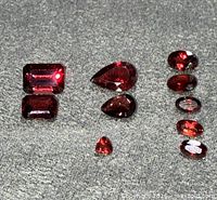 All ten garnets laid out showing various cuts and deep red color