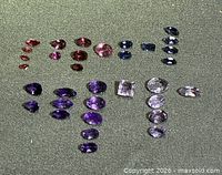 All 32 gemstones arranged by color on felt background