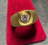 Front view of ring showing bezel-set stone and brushed rectangular top