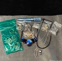 Full lot showing bags of findings, two necklaces, blue tool