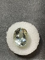 Front view of oval faceted aquamarine on white foam