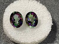 Front view of both oval faceted mystic topaz stones showing rainbow iridescence
