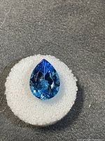 Pear-cut blue gemstone on white foam display