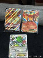 Front view of Eevee VMAX, Ho-Oh EX and Shaymin EX cards in sleeves