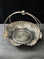 Angled view showing scalloped rim, spiral base, swing handle up