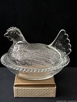 Side view of assembled clear glass hen on nest dish