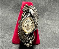 Front view showing watch dial and ornate sterling silver leaf design