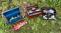 All three open toolboxes showing contents on ground