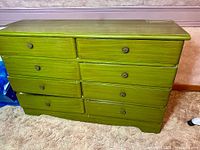 Front view of green 8-drawer dresser showing all drawers and knobs