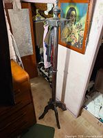 Full view of antique metal coat tree showing entire structure from finial to base