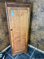 Full front view of wooden single-door armoire