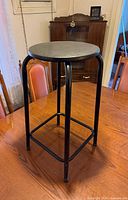 Full view of black metal bar stool on table