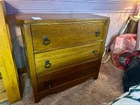 Front view of solid ash dresser showing three drawers and hardware