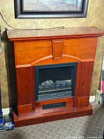 Front view of electric fireplace showing wood mantel and insert
