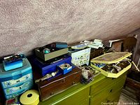 wide view of all jewelry boxes, organizers and contents on green dresser