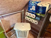 Overall view showing hamper, clothing rack, wire shelf with paper towels