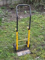 Full view of hand truck standing on grass