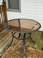 Full view of round glass patio table on deck