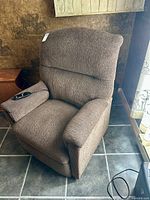 Front angled view of brown fabric La-Z-Boy power recliner with remote on armrest