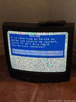 RCA CRT TV powered on displaying setup menu with remote on top