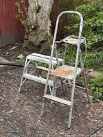 Both metal 2-step ladders outdoors showing overall condition