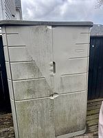 Closed beige resin cabinet showing exterior condition